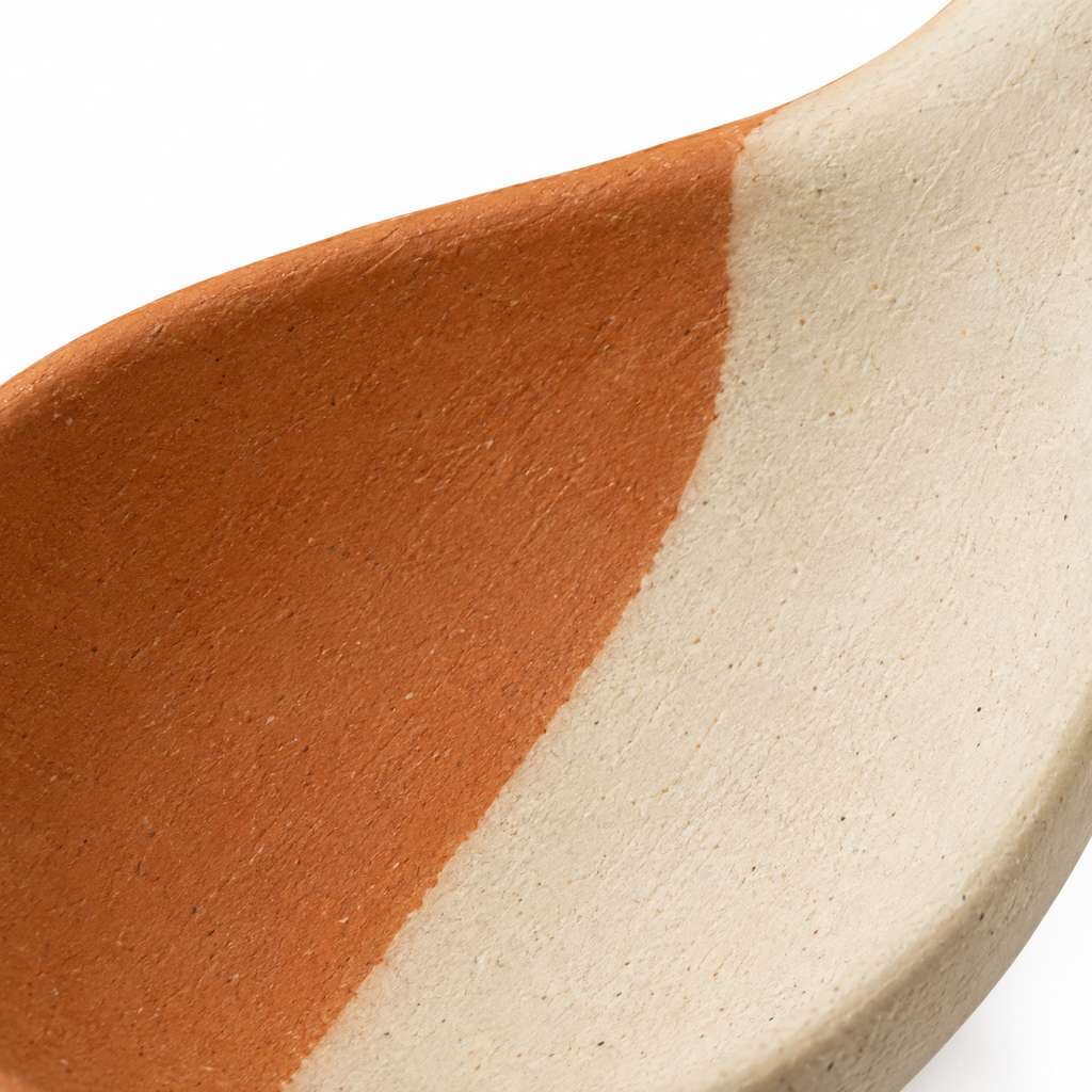 Elegant dual-tone ceramic spoon for cooking and serving.