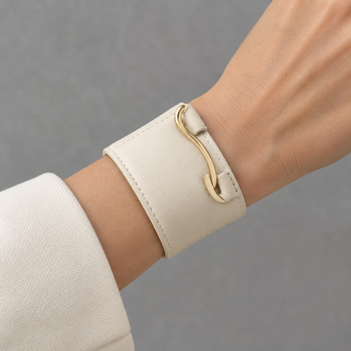Close-up of gold hook closure on leather bracelet.