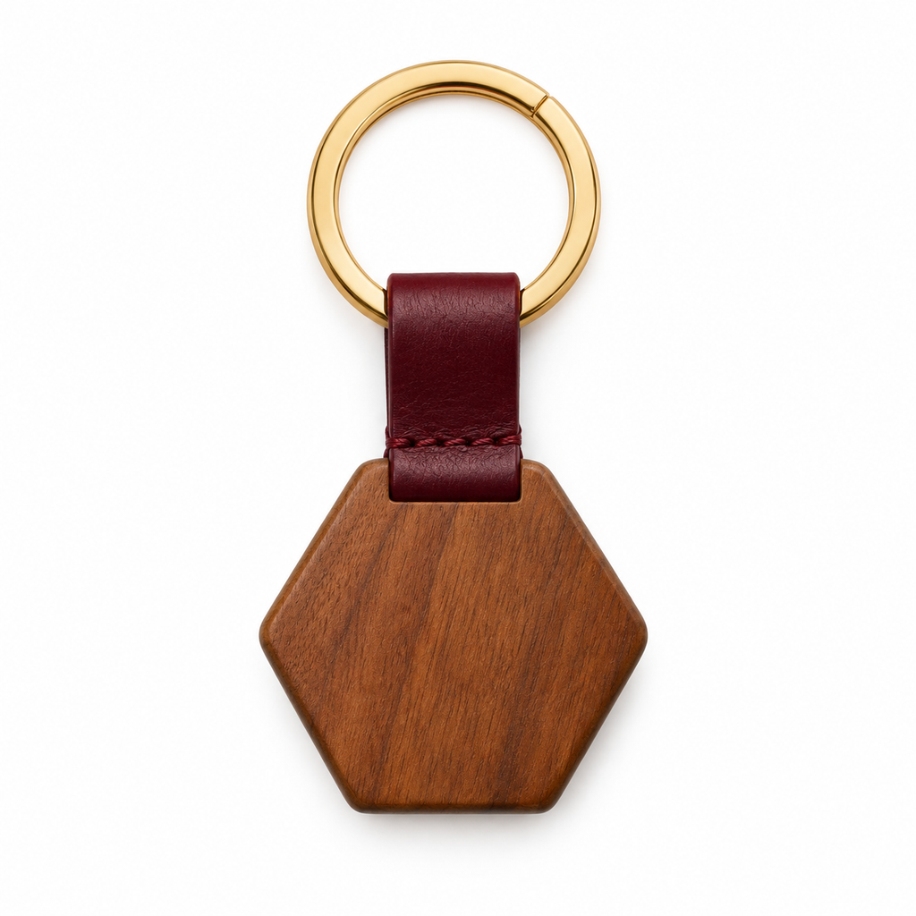 Hexagonal wooden keychain with leather strap and gold ring.