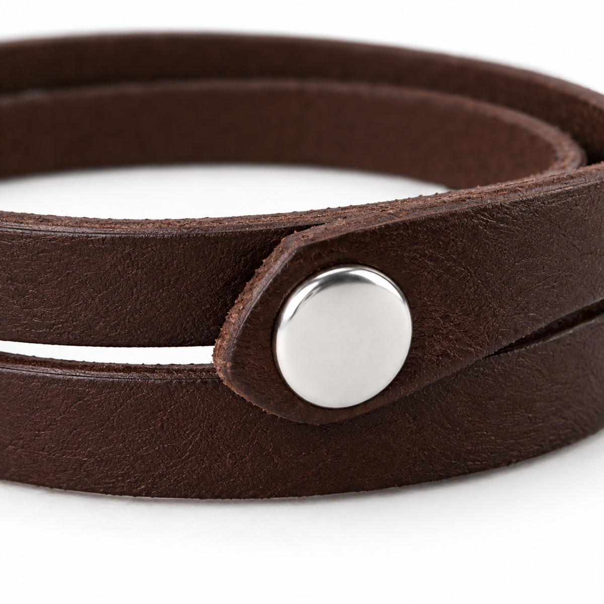 Men's brown leather bracelet displayed on a surface.