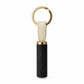 Front view of charcoal keychain with gold ring and leather strap.