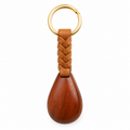 Wooden keychain with braided leather strap and gold ring.