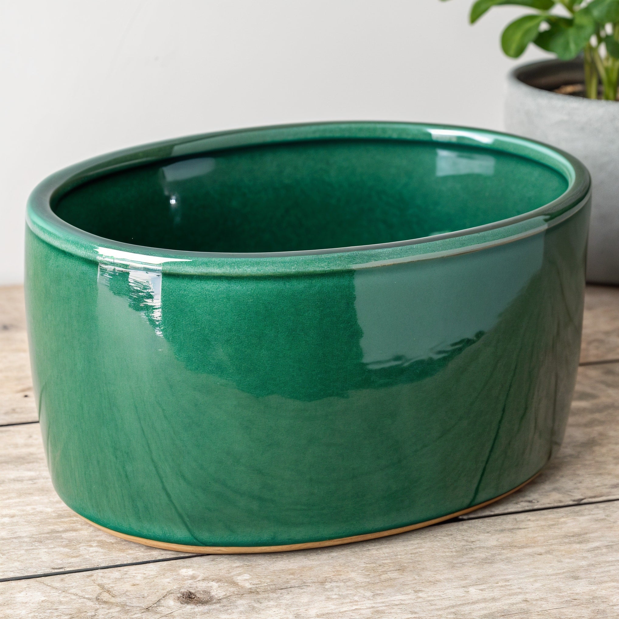 Vensioshop Emerald Green Oval Ceramic Planter — three-quarter front view showing the glossy emerald green finish